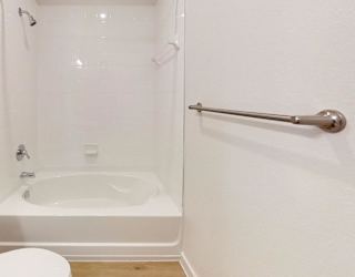 A white toilet sits next to a bathtub in a bathroom.