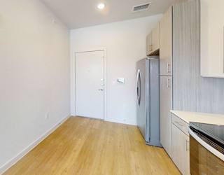 A kitchen with a refrigerator and a washing machine.