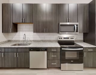 a kitchen with dark wood cabinets and white countertops