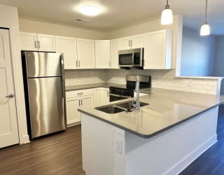 a kitchen with white cabinets and stainless steel appliances  at Signature Pointe Apartment Homes, Athens, 35611
