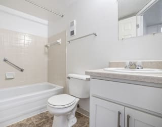 a bathroom with a sink toilet and a bath tub at Apple Ridge Apartments, Michigan, 49534