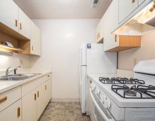 a kitchen with a stove and a sink and a refrigerator  at Apple Ridge Apartments, Walker, Michigan