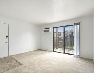 an empty living room with a slider to a balcony at Apple Ridge Apartments, Michigan, 49534