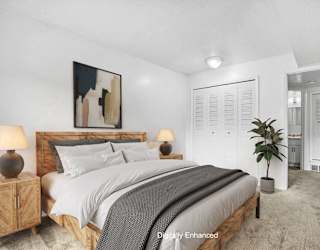 A bedroom with a large bed and closet at Apple Ridge Apartments, Walker, MI