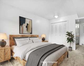 A bedroom with a large bed and closet  at Apple Ridge Apartments, Walker, MI