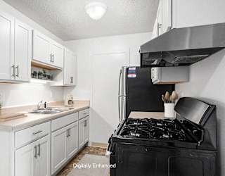 A kitchen with white cabinets and stainless steel appliances  at Apple Ridge Apartments, Walker, MI