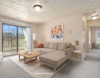a living room with a couch and a slider to a balcony at Apple Ridge Apartments, Walker
