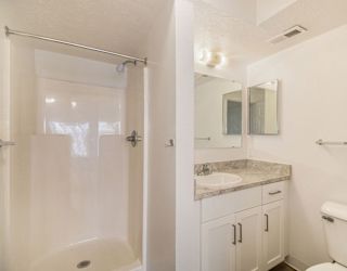 A bathroom with a shower, toilet, and sink at Brentwood Park Apartments in LaVista, NE