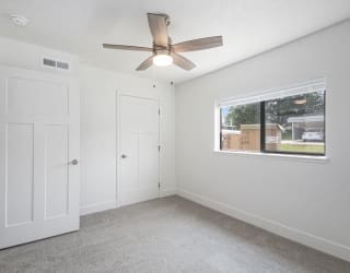 bedroom with a ceiling fan and a window at The Crossings Apartments, Michigan, 49508