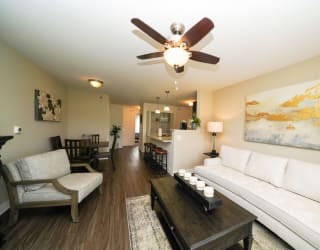 A living and dining room with a ceiling fan at Copper Creek Apartment Homes, Maize, KS, 67101