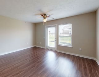 Two bedroom living room with hard surface flooring at Copper Creek Apartment Homes, Maize