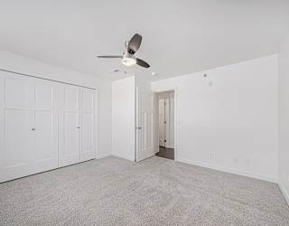A bedroom with a ceiling fan and carpeted floor at Copper Creek Apartment Homes, Kansas, 67101