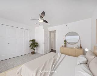 A bedroom with a bed, dresser, mirror, and a ceiling fan at Copper Creek Apartment Homes, Kansas, 67101