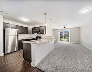 A kitchen with a refrigerator, microwave, and a countertop with a sink at Copper Creek Apartment Homes, Kansas, 67101