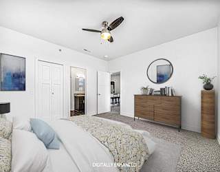 A 2nd bedroom with an ensuite, a bed, dresser, and ceiling fan at Copper Creek Apartment Homes, Maize, Kansas