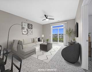 A modern living room with a 9' ceiling, a ceiling fan, and a grey sofa at Copper Creek Apartment Homes, Maize, Kansas
