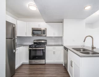 kitchen with white cabinets and stainless steel appliances at The Crossings Apartments, Michigan, 49508