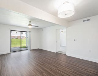 living room with hard surface flooring and a sliding glass door to a patio at The Crossings Apartments, Michigan, 49508