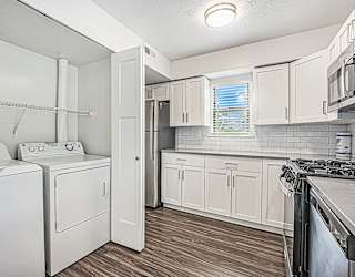 A kitchen with a washer and dryer at The Crossings Apartments in Grand Rapids, MI