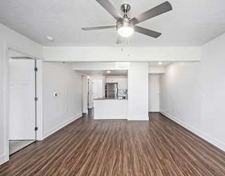 A living room with a ceiling fan at The Crossings Apartments in Grand Rapids, MI