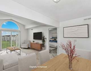 A living room with a cathedral ceiling at Dupont Lakes Apartments in Fort Wayne, IN