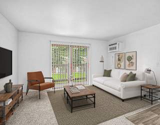 A living room with a slider to a balcony at Fairlane Apartments in MI 49037