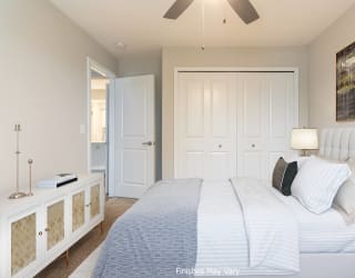 a bedroom with a large bed and a ceiling fan at Hillside Apartments, Wixom, MI