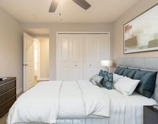 a bedroom with a large bed and a ceiling fan at Hillside Apartments, Michigan, 48393