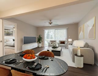 a living room and dining room with a large window and a ceiling fan at Hillside Apartments, Wixom, MI