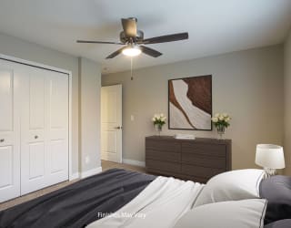 a bedroom with two closets and a ceiling fan at Hillside Apartments, Michigan