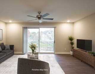 a living room with a couch and a tv at Hillside Apartments, Wixom