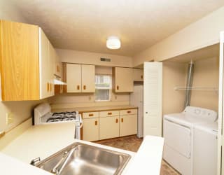 a kitchen with a sink and a washer and dryer  at Hurwich Farms Apartments, South Bend, IN