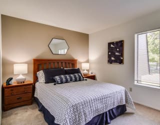 a bedroom with a large window and a large bed  at Sycamore Creek Apartments, Lake Orion
