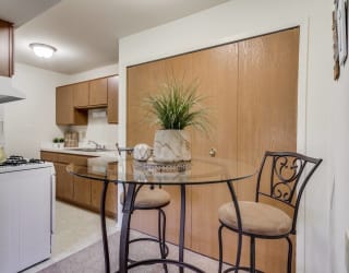 a kitchenette with a small table and two chairs  at Sycamore Creek Apartments, Lake Orion, Michigan