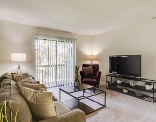 a living room with a couch and a tv  at Sycamore Creek Apartments, Lake Orion, Michigan