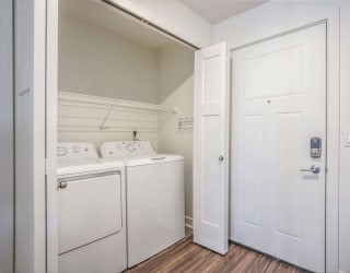 a laundry room with a washer and dryer and a white door at Meadowbrooke Apartment Homes, Grand Rapids, 49512