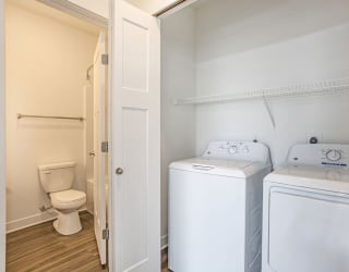 a washer and dryer in a room with a toilet at Meadowbrooke Apartment Homes, Grand Rapids