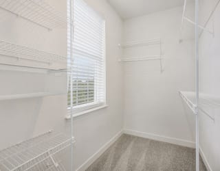 a closet with white walls and a window in a room with white closets at Meadowbrooke Apartment Homes, Michigan, 49512