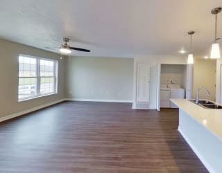 an empty living room and kitchen with a counter top at Meadowbrooke Apartment Homes, Michigan
