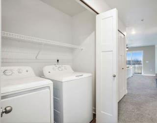 a white laundry room with two washes and a dryer at Meadowbrooke Apartment Homes, Grand Rapids, Michigan