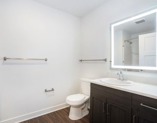 a bathroom with a toilet sink and mirror at Meadowbrooke Apartment Homes, Grand Rapids, Michigan