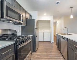 an empty kitchen with stainless steel appliances and wooden floors at Meadowbrooke Apartment Homes, Grand Rapids, 49512
