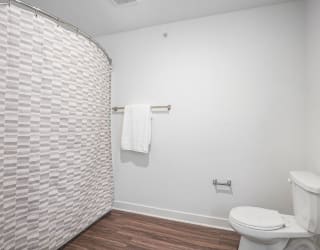 a white bathroom with a toilet and a shower at Meadowbrooke Apartment Homes, Michigan