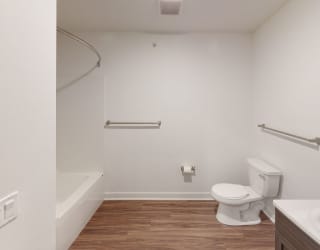 a bathroom with a toilet and a sink and a bath tub at Meadowbrooke Apartment Homes, Grand Rapids, 49512