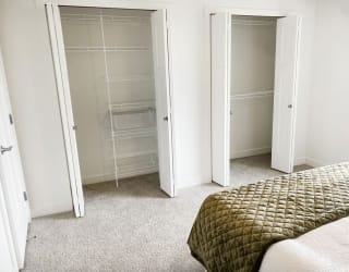 a bedroom with closet doors and a bed at Meadowbrooke Apartment Homes, Grand Rapids, Michigan