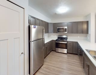 a kitchen with stainless steel appliances and wooden cabinets at Meadowbrooke Apartment Homes, Grand Rapids, 49512