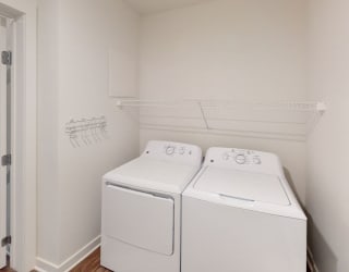 a washer and dryer in a room with a door at Meadowbrooke Apartment Homes, Grand Rapids, Michigan
