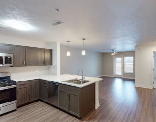 an empty kitchen and living room with wood flooring and at Meadowbrooke Apartment Homes, Grand Rapids, MI