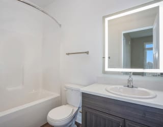 a bathroom with a sink toilet and a mirror at Meadowbrooke Apartment Homes, Grand Rapids, 49512