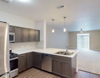 an empty kitchen and living room with wood flooring at Meadowbrooke Apartment Homes, Michigan, 49512